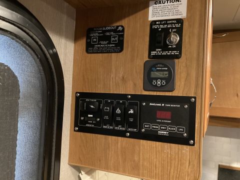2015 Ford F-550 - Control panel inside an RV shows various system switches and a tank level monitor.