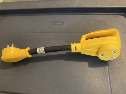 2015 Ford F-550 - This yellow RV power adapter features a black cable and visible labels indicating its specifications.