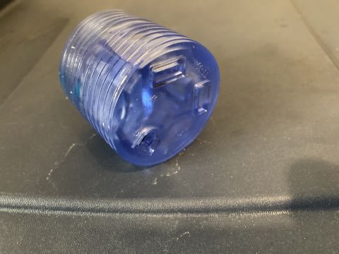2015 Ford F-550 - A blue electrical plug is shown resting on a dark surface.