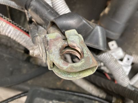 2015 Ford F-550 - Close-up of a corroded battery terminal clamp, showing wear and tear on the metal.
