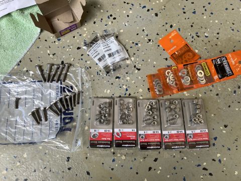 2015 Ford F-550 - A collection of stainless steel fasteners, including bolts, nuts, and washers, are displayed on a garage floor.