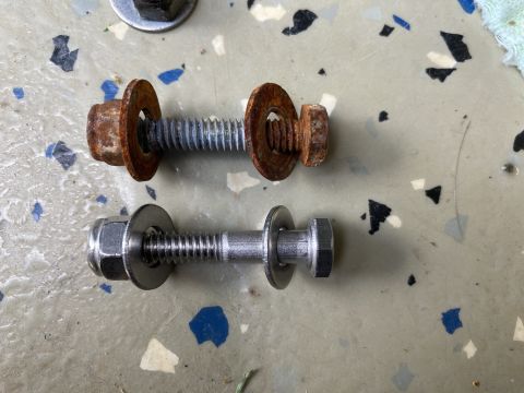 2015 Ford F-550 - Comparison of a rusted bolt and washer set with a new one on a speckled surface.