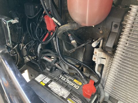 2015 Ford F-550 - The engine bay of a vehicle, a Duracell battery and extensive wiring.