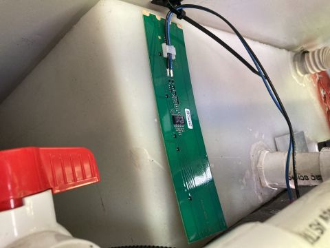 2015 Ford F-550 - A circuit board, likely for a level sensor, is mounted inside a tank, adjacent to plumbing fixtures.