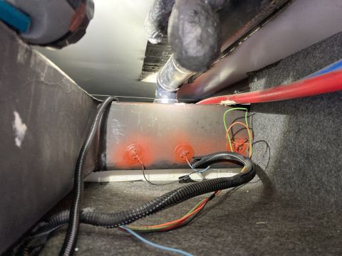 2015 Ford F-550 - Plumbing and wiring components visible underneath a vehicle, with a metal tank as the central focus.