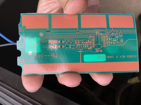 2015 Ford F-550 - A circuit board with visible text and components is held for inspection.