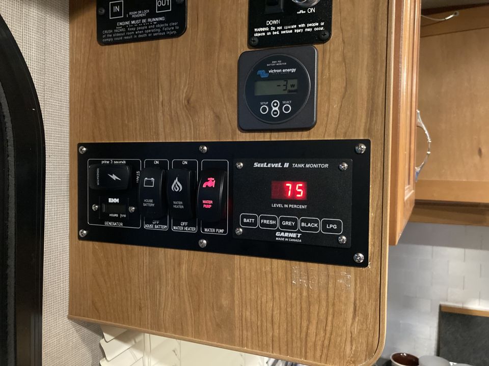 SeeLevel II Tank Monitor panel showing 75% level, with switches for generator, batteries, and water pump