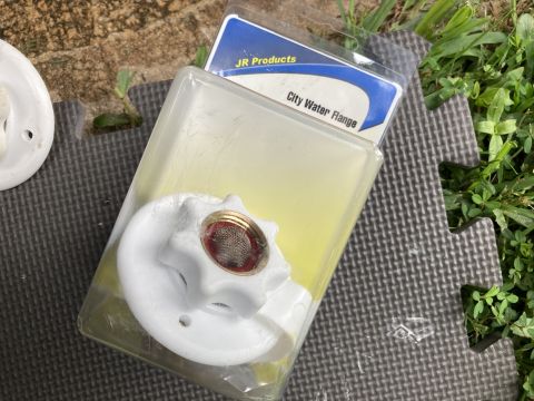 2015 Ford F-550 - A city water flange part is shown in its packaging on a textured surface.