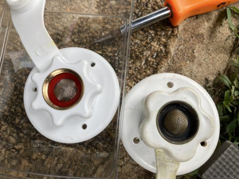 2015 Ford F-550 - Close-up of two plumbing valve handles and filters, with a screwdriver nearby.