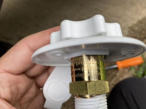 2015 Ford F-550 - Close-up of a white plastic water inlet fitting with a brass connector showing text 'jr products' and 'made in china'.