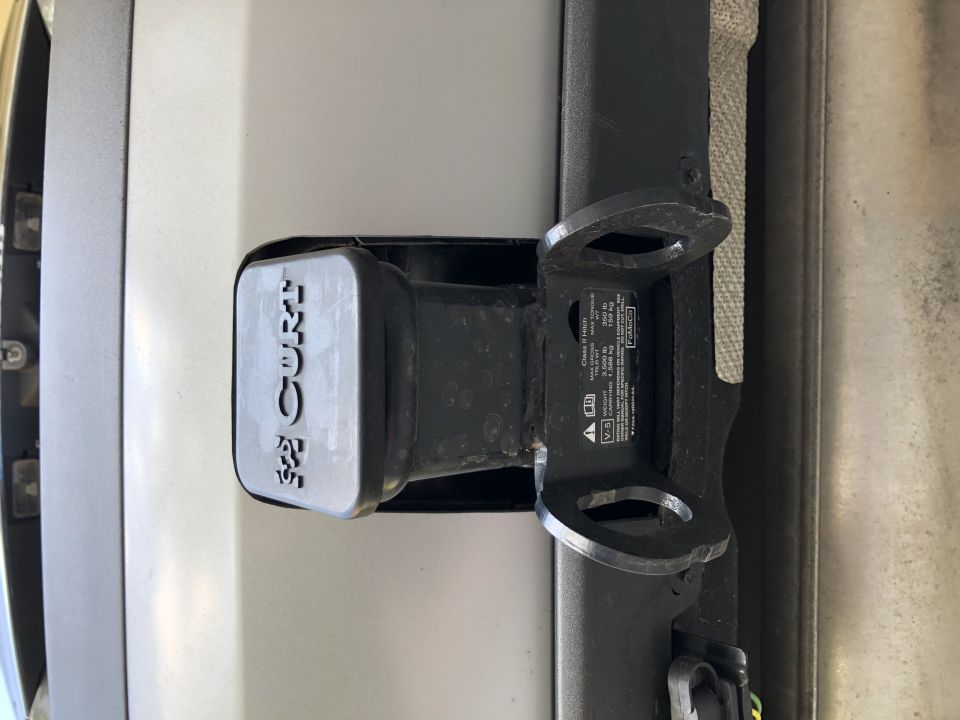 CURT brand tow hitch receiver cover and mounting bracket. Text on bracket lists weight capacities
