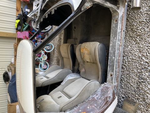 Car interior showing worn bucket seats and door panel, with bicycles in the background