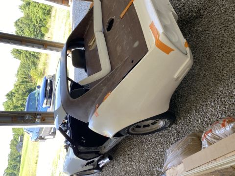 1976 Chevrolet Corvette body undergoing restoration, showing interior and unfinished exterior panels
