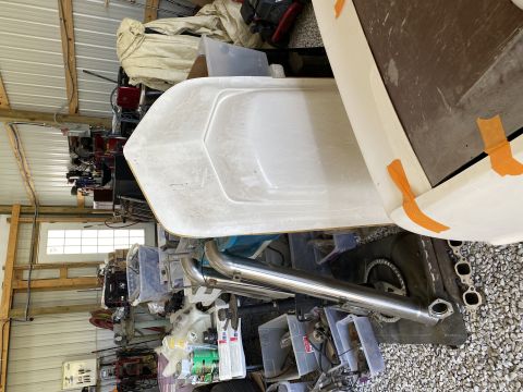 White boat hull and exhaust pipe in a cluttered garage