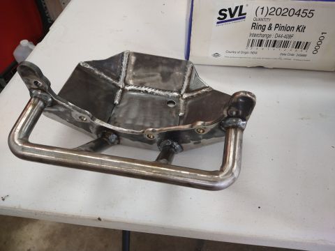 1996 Ford Bronco - A fabricated metal differential cover sits on a table next to a box containing a ring and pinion kit.