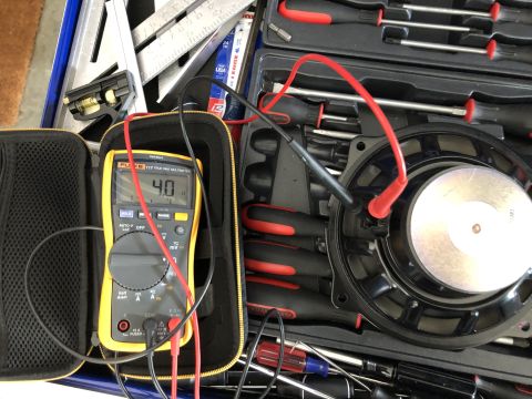 2019 Ford Everest - A speaker is tested with a Fluke multimeter, displaying a reading of 40 ohms, surrounded by various tools.