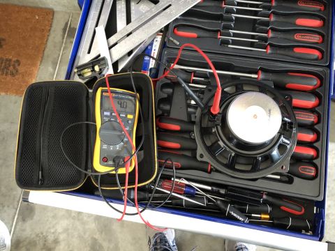 2019 Ford Everest - Testing a speaker with a multimeter alongside a set of screwdrivers and measuring tools.