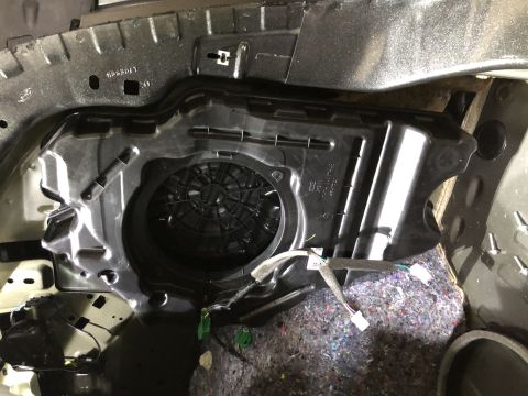 2019 Ford Everest - The interior of a vehicle shows a black speaker housing with visible wiring and insulation material.
