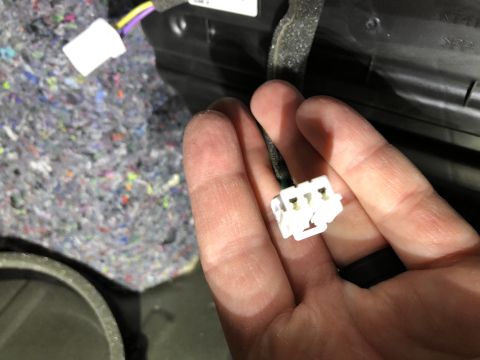 2019 Ford Everest - Close-up of a hand holding a white electrical connector with wires.