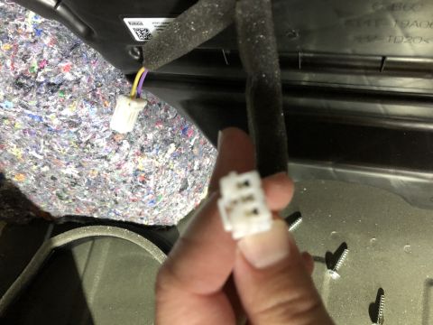 2019 Ford Everest - A person is holding a disconnected wiring harness connector inside a vehicle's interior.
