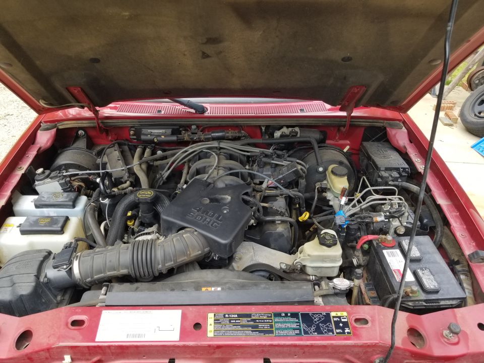 The engine bay looks good, but the battery is virtually dead.