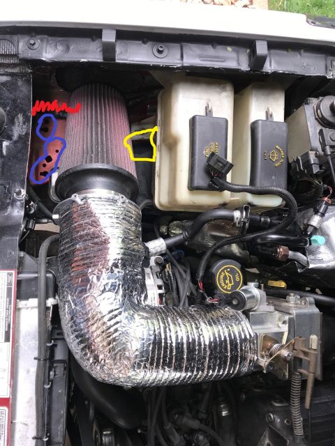 2000 Ford Explorer - The engine bay of a 2000 Ford Explorer shows a modified cold air intake system with a large red air filter and silver insulated tubing. Two…