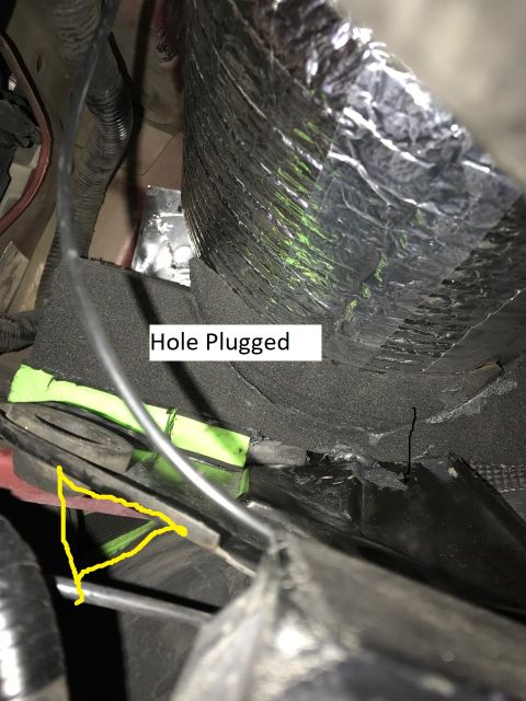 2000 Ford Explorer - A close-up view shows a black foam material that has been used to plug a hole. A yellow triangle highlights a metal bracket and wiring near…