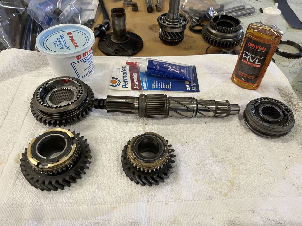 Transmission parts including gears, shaft, synchronizer rings, assembly lube, gasket maker, and oil.