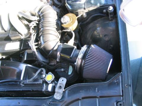 1986 Ford F-150 - Close-up view of an engine bay an aftermarket air intake system and radiator components.