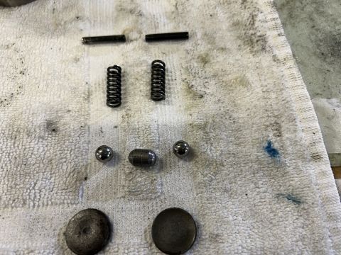 1979 Jeep CJ5 - Several small metal engine parts are laid out on a white towel. The parts include two springs, two cylindrical pins, two ball bearings, a r…