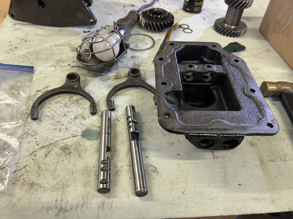 Jeep CJ5 transmission parts laid out on a workbench.