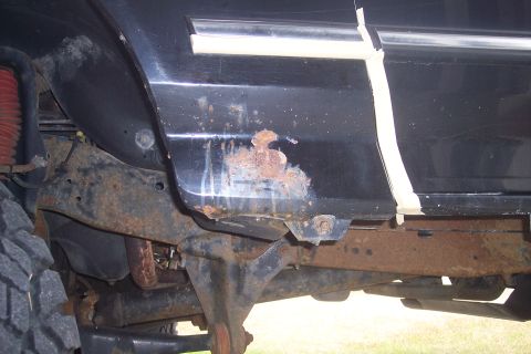 1995 Ford Bronco - Repair work being done on a vehicle's frame with a welding torch.