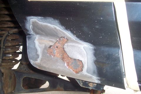 1995 Ford Bronco - Close-up view of a fender patch repair, showing welding and primer application.