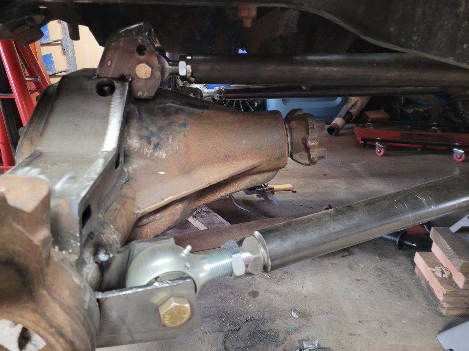 Modified rear axle with adjustable control arms and suspension components. Rusty differential housing