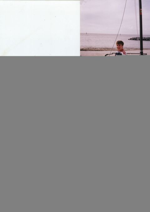 1982 Ford Bronco - A boy stands on a sailboat mast at the beach with the ocean in the background.