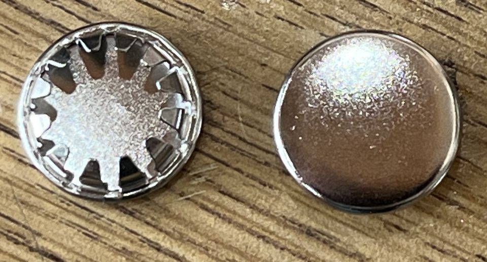 Two metallic, circular objects, one with a star pattern, on a wooden background.