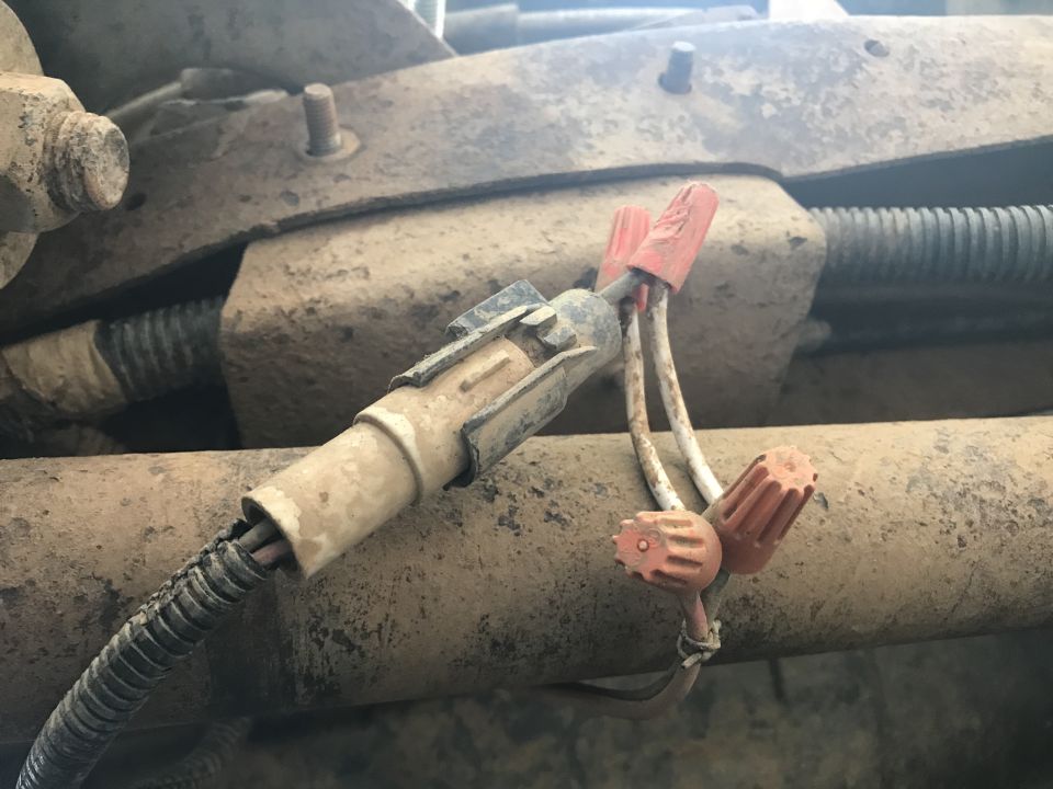 Close-up of dirty vehicle electrical connector with orange wire nuts