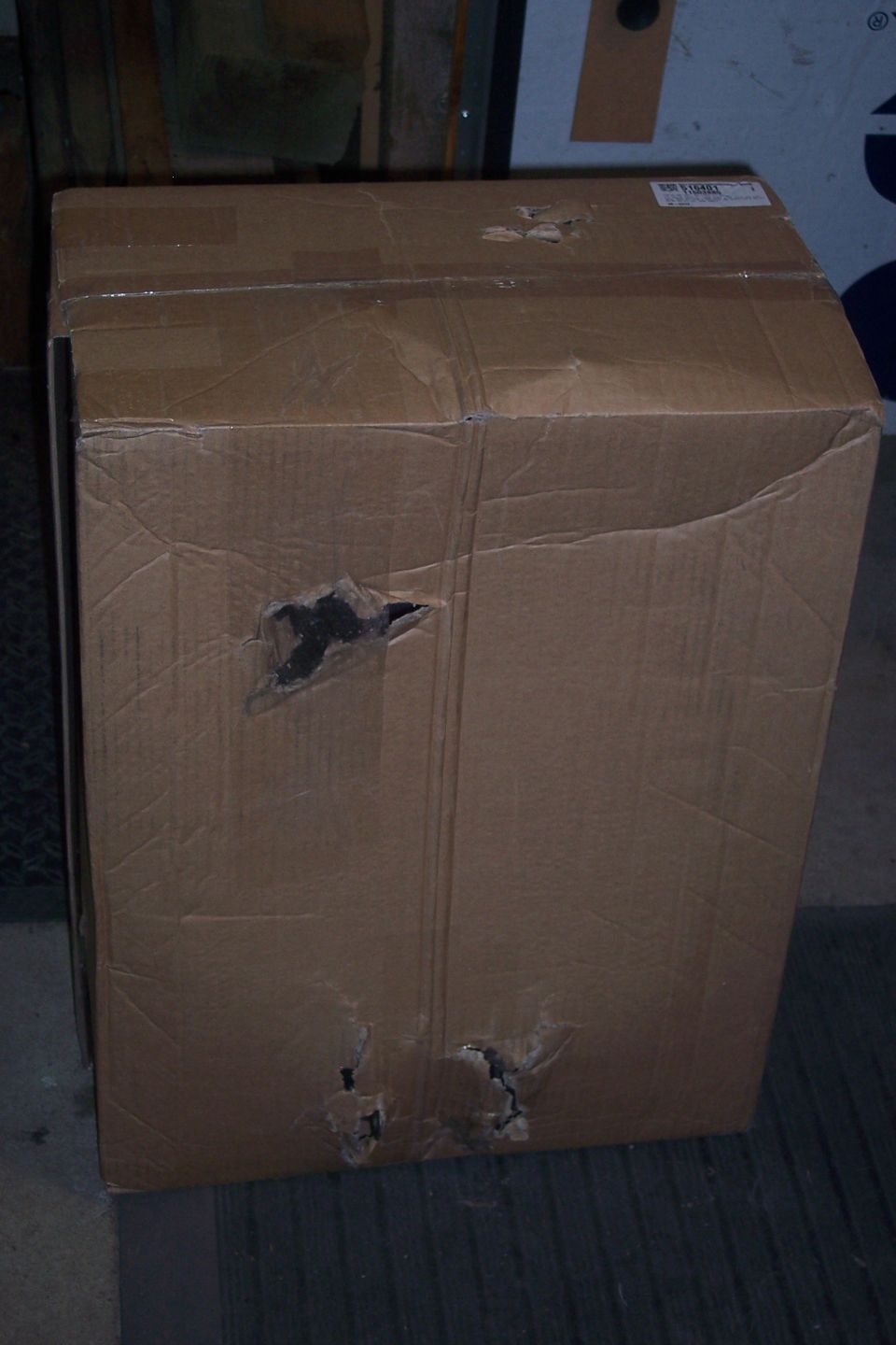 Damaged cardboard box with holes in the side.