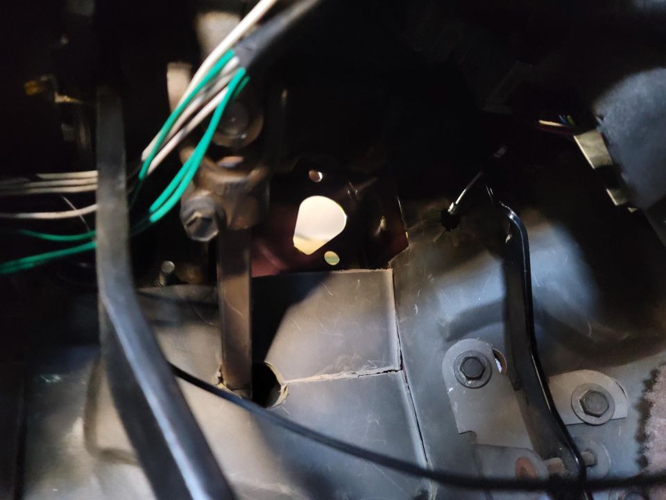 Close-up of wiring and a metal bracket inside a vehicle