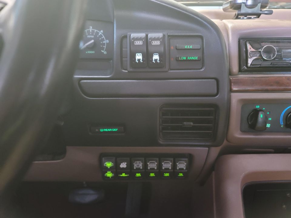 Dashboard with various switches for 4x4, low range, and rear diff. Also shows speedometer and radio