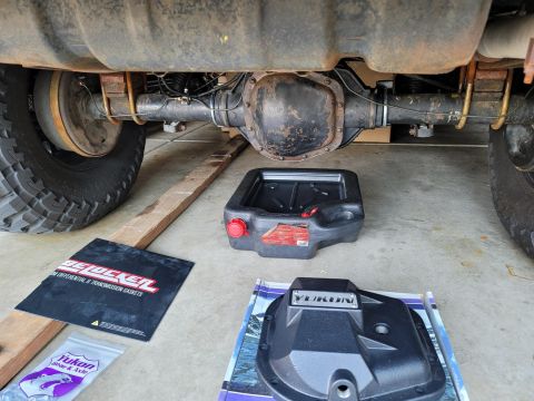 1996 Ford Bronco - Yukon differential cover and related parts laid out for installation on a vehicle's rear axle.