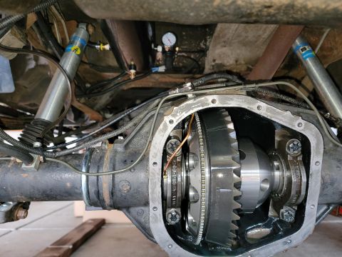 1996 Ford Bronco - Close-up view of the internal gears of a rear differential, with suspension components in the background.