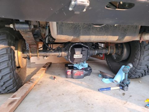 1996 Ford Bronco - Working on the rear differential cover of a vehicle, with tools and supplies laid out.