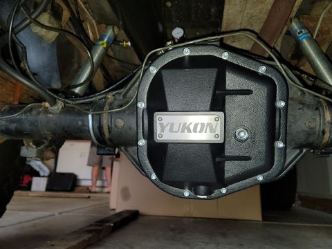 1996 Ford Bronco - Close-up of a Yukon brand differential cover installed on a vehicle's rear axle, with visible shocks and brake lines.