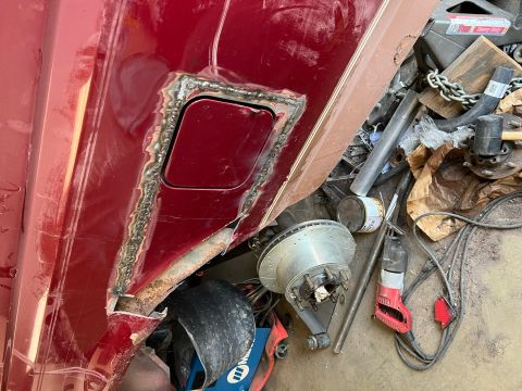1995 Ford Bronco - Welding repair on a red vehicle's body panel, with various automotive parts and tools visible.