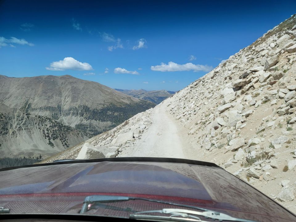 Red dashboard and windshield view of a mountain road