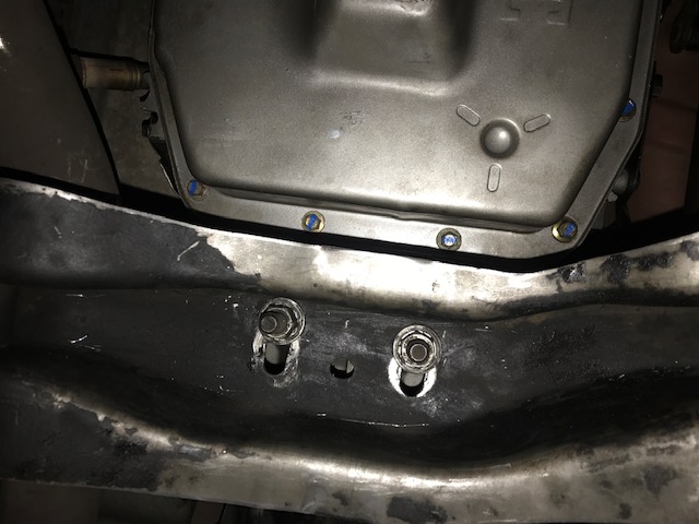 Transmission pan with blue bolts and frame with two bolts visible