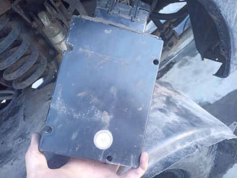 2001 Ford Excursion - Black vehicle control module with connector is held by a hand.