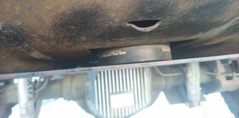 2001 Ford Excursion - Close-up of a vehicle's undercarriage, focusing on the differential and a part with text.