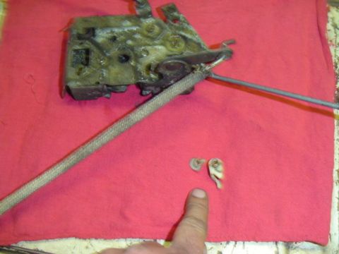 1979 Ford Bronco - A disassembled door latch mechanism is shown, with two small clips broken off.